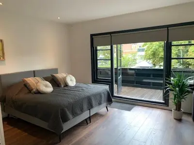 a bedroom with a bed and a sliding glass door at B&B aan de Gracht in Alkmaar