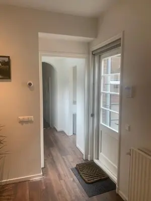 an empty room with a hallway with a window at B&B aan de Gracht in Alkmaar
