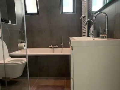 a bathroom with a sink and a tub and a toilet at B&B aan de Gracht in Alkmaar