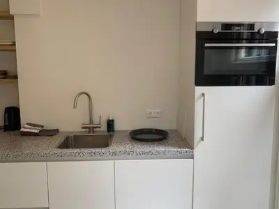 a kitchen with a sink and a stove at B&B aan de Gracht in Alkmaar