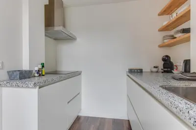 a white kitchen with a sink and a counter top at B&B aan de Gracht in Alkmaar