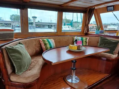 a bench with a table in the middle of a boat at Motorjacht At Ease in Amsterdam