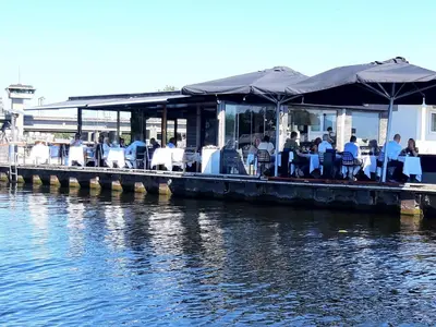 a restaurant on a dock next to a body of water at Motorjacht At Ease in Amsterdam