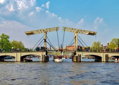 a bridge over a river with boats on the water at Motorjacht At Ease in Amsterdam