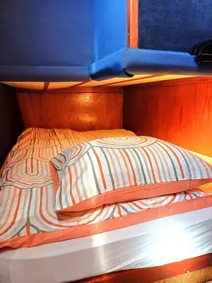 an upper bunk of a bunk bed with a striped comforter at Motorjacht At Ease in Amsterdam