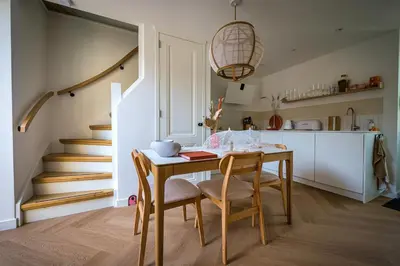 a kitchen and dining room with a table and chairs at 5 O Clock Somewhere in Bergen