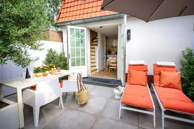 a patio with a table and chairs and an umbrella at 5 O Clock Somewhere in Bergen