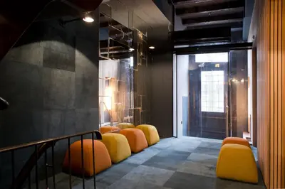 a row of yellow and orange chairs in a room at Boutique Hotel Oosteinde in Amsterdam