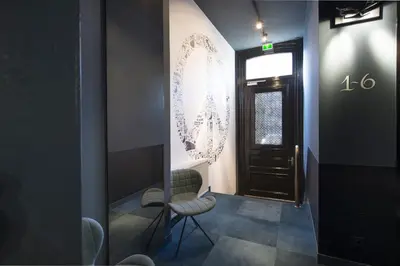 a hallway with a door and a chair and a window at Boutique Hotel Oosteinde in Amsterdam