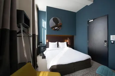 a blue bedroom with a bed and a chair at Boutique Hotel Oosteinde in Amsterdam