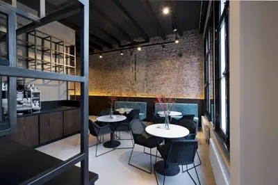 a restaurant with two tables and chairs and a brick wall at Boutique Hotel Oosteinde in Amsterdam
