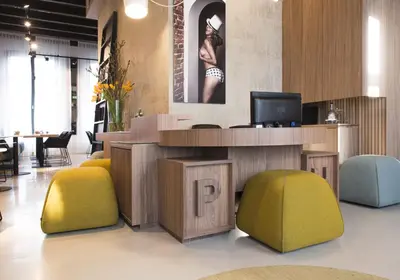 a lobby with a desk with a tv and colorful chairs at Boutique Hotel Oosteinde in Amsterdam