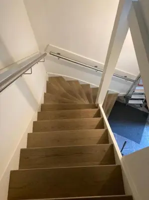 a staircase in a room with wooden stairs at Hoogwaardig afgewerkt loft in oude stadscentrum in Alkmaar