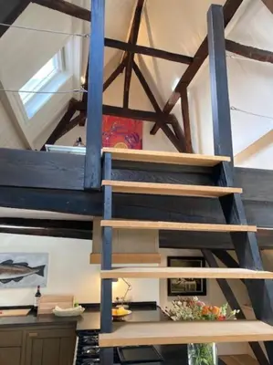 a wooden staircase in a room with a ceiling at Hoogwaardig afgewerkt loft in oude stadscentrum in Alkmaar