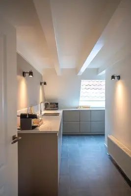 a kitchen with white counters and a window at Amersfoort City Center Apartment StadsHart in Amersfoort