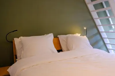 a bedroom with a bed with white sheets and pillows at Amersfoort City Center Apartment StadsHart in Amersfoort