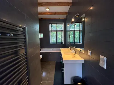 a bathroom with two sinks and a bath tub at Yourbnb Suites Kerkstraat in Amsterdam