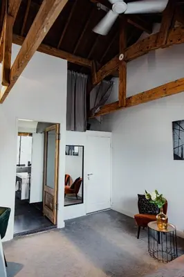 a living room with white walls and wooden ceilings at Yourbnb Suites Kerkstraat in Amsterdam