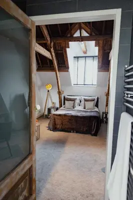 a bedroom with a bed in a room with wooden ceilings at Yourbnb Suites Kerkstraat in Amsterdam