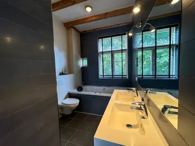 a bathroom with two sinks and a tub and a toilet at Yourbnb Suites Kerkstraat in Amsterdam