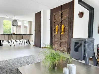 a living room with a fireplace and a dining room at Bungalow 77 op Recreatiepark De Wielen in Sint Maarten