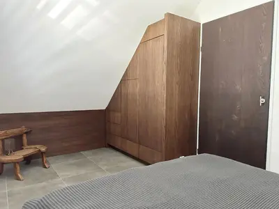 a bedroom with a bed and a wooden wall at Bungalow 77 op Recreatiepark De Wielen in Sint Maarten