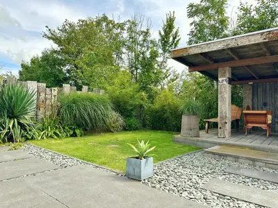 a garden with a gazebo and a grass yard at Bungalow 77 op Recreatiepark De Wielen in Sint Maarten