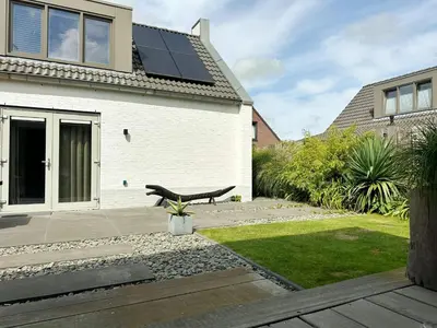 a house with solar panels on the roof at Bungalow 77 op Recreatiepark De Wielen in Sint Maarten