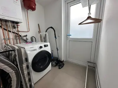 a laundry room with a washing machine and a window at Bungalow 77 op Recreatiepark De Wielen in Sint Maarten