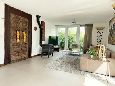a living room with a wooden door and a couch at Bungalow 77 op Recreatiepark De Wielen in Sint Maarten