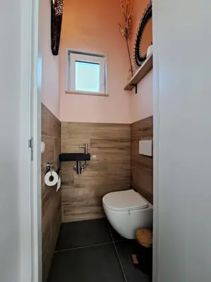 a bathroom with a toilet and a sink and a window at Have a nice stay! - Vakantiehuis Buitenplaats in Noordwijkerhout
