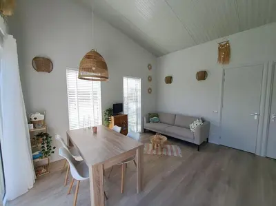 a living room with a table and a couch at Have a nice stay! - Vakantiehuis Buitenplaats in Noordwijkerhout