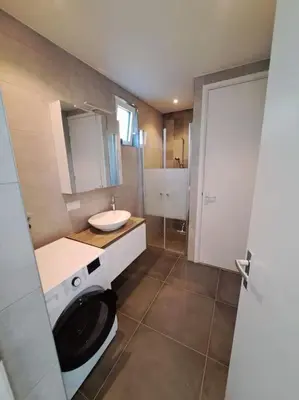 a bathroom with a washing machine and a sink at Have a nice stay! - Vakantiehuis Buitenplaats in Noordwijkerhout