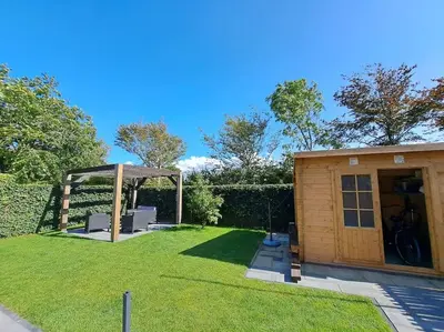 a small shed with a gazebo in a yard at Have a nice stay! - Vakantiehuis Buitenplaats in Noordwijkerhout