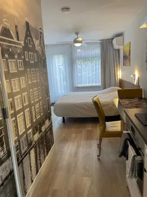 a hotel room with a bed and a desk and a desk at The Duck of Amsterdam in Amsterdam
