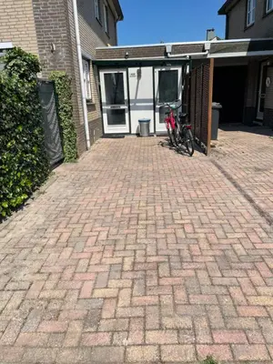 a bike parked on a brick driveway in front of a house at The Duck of Amsterdam in Amsterdam
