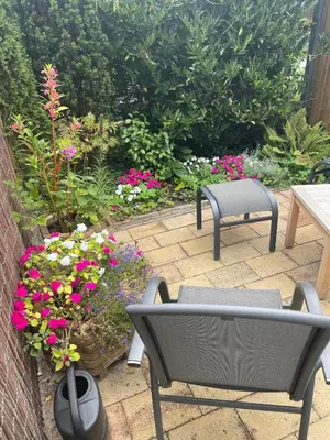 a patio with a table and chairs and flowers at The Duck of Amsterdam in Amsterdam