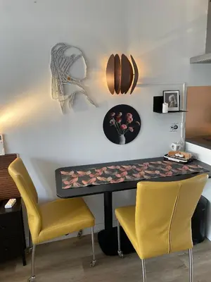 a dining room table with two yellow chairs and a table with flowers at The Duck of Amsterdam in Amsterdam