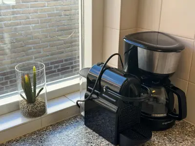 a coffee maker sitting on a counter next to a window at Vakantiewoning Zon, Zee & Duin - Egmond aan Zee in Egmond aan Zee