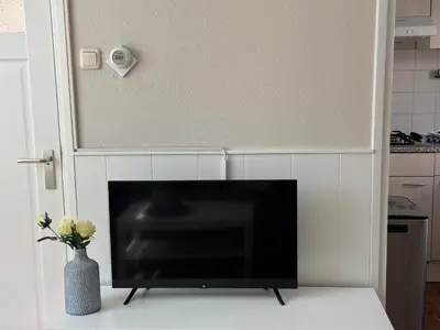a flat screen tv sitting on a table in a kitchen at Vakantiewoning Zon, Zee & Duin - Egmond aan Zee in Egmond aan Zee