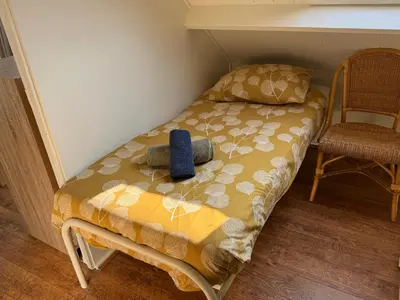 a small bed in a room with a blue bottle on it at Vakantiewoning Zon, Zee & Duin - Egmond aan Zee in Egmond aan Zee