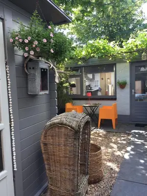 a wicker chair sitting on the side of a house at Appartement 't Zomerhuis in Zandvoort