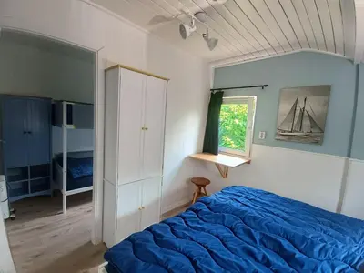 a bedroom with a blue bed and a window at Relax Cozy Dirkshorn Stay in Dirkshorn