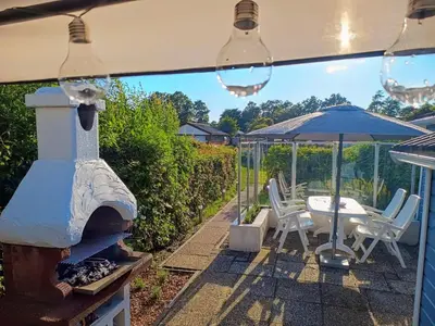 a patio with an umbrella and a table and chairs at Relax Cozy Dirkshorn Stay in Dirkshorn