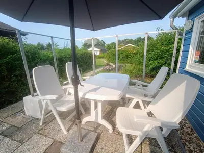 a table and four chairs and an umbrella on a patio at Relax Cozy Dirkshorn Stay in Dirkshorn