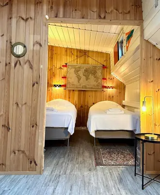two beds in a room with wooden walls at Houseboat De Cornelia in Amsterdam