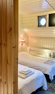 two beds in a small room with a window at Houseboat De Cornelia in Amsterdam