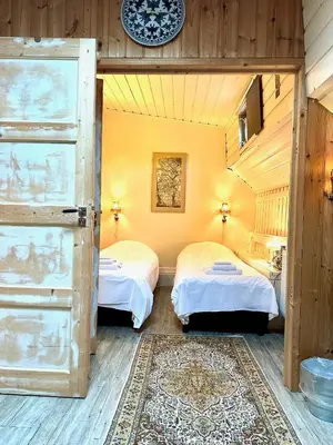 a bedroom with two beds and a door with a rug at Houseboat De Cornelia in Amsterdam