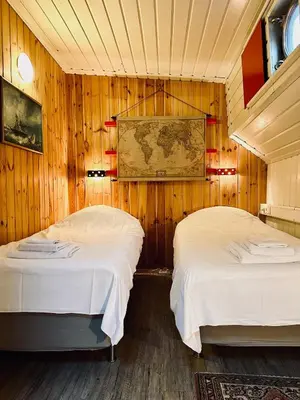 two beds in a room with wooden walls at Houseboat De Cornelia in Amsterdam