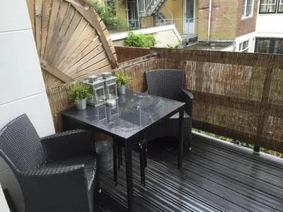 a balcony with a table and chairs on a deck at Rosies Place in Amsterdam